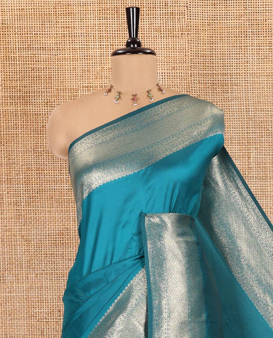 Blue Plain Semi-Soft Silk Saree, Adorned with Traditional Zari Designs Woven Border, Grandly Woven Pallu Steeped with Chakram Designs, and Paired with a Matching Blouse