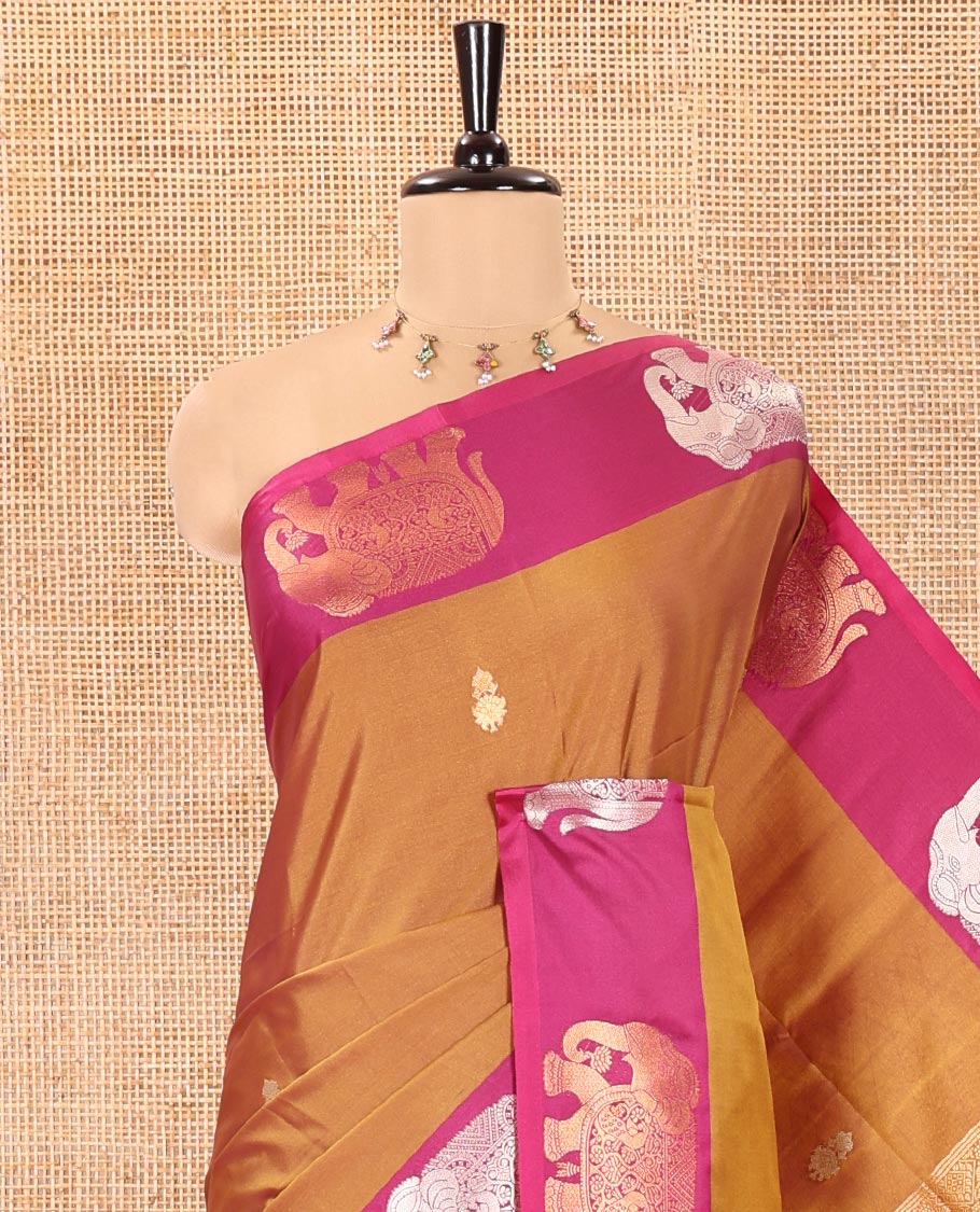 Brown Soft Silk Saree, Adorned With Zari Buttas All Over Its Body, Complemented by Captivating Contrast Border of Elephant Motifs, Grandly Decked Up Pallu, and Paired with a Contrast Blouse