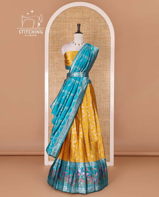 Haldi yellow taffeta silk half saree, floral jaal jacquard skirt, contrast green zari meenakari style bird border, matching blouse, and floral jaal dhavani