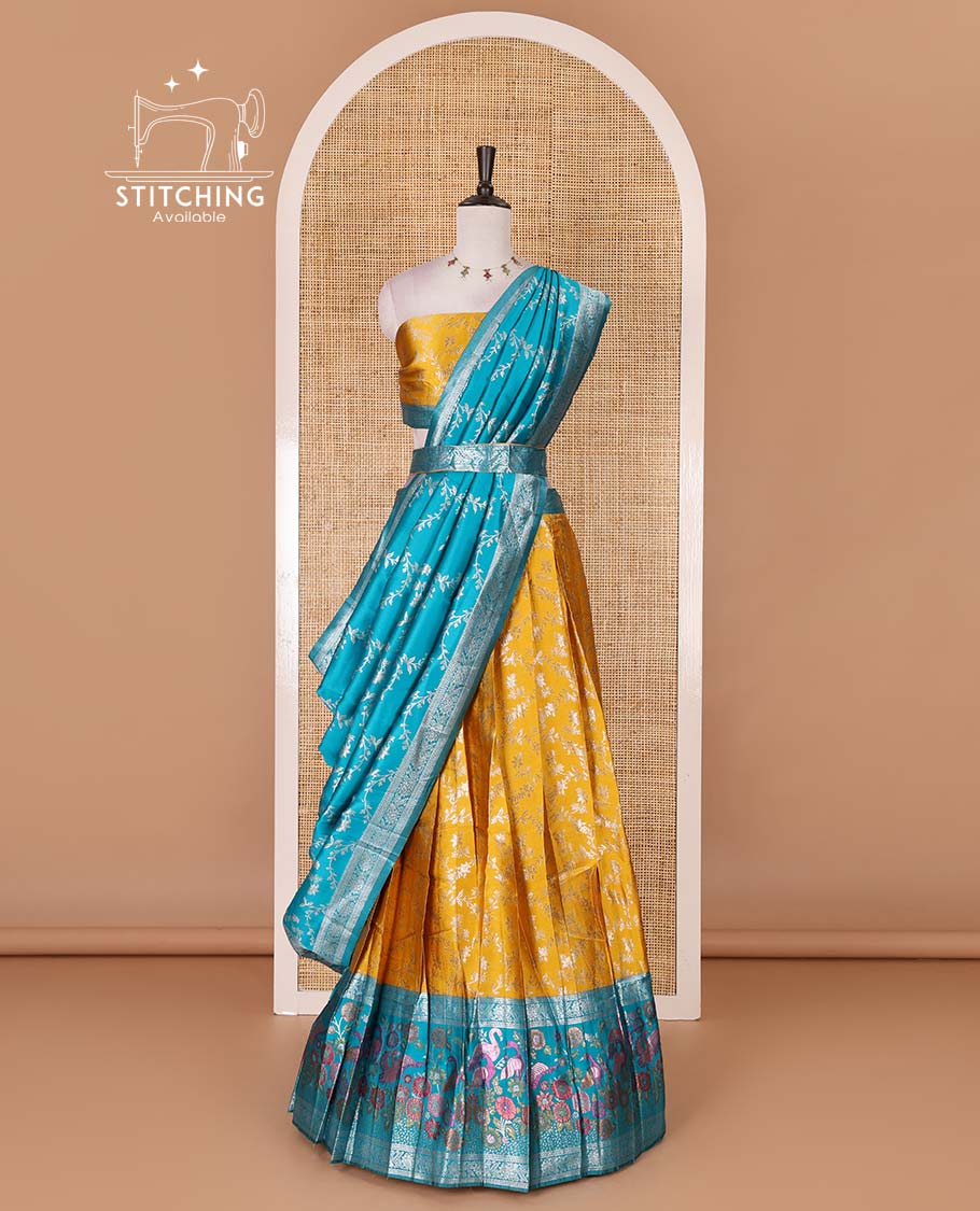 Haldi yellow taffeta silk half saree, floral jaal jacquard skirt, contrast green zari meenakari style bird border, matching blouse, and floral jaal dhavani
