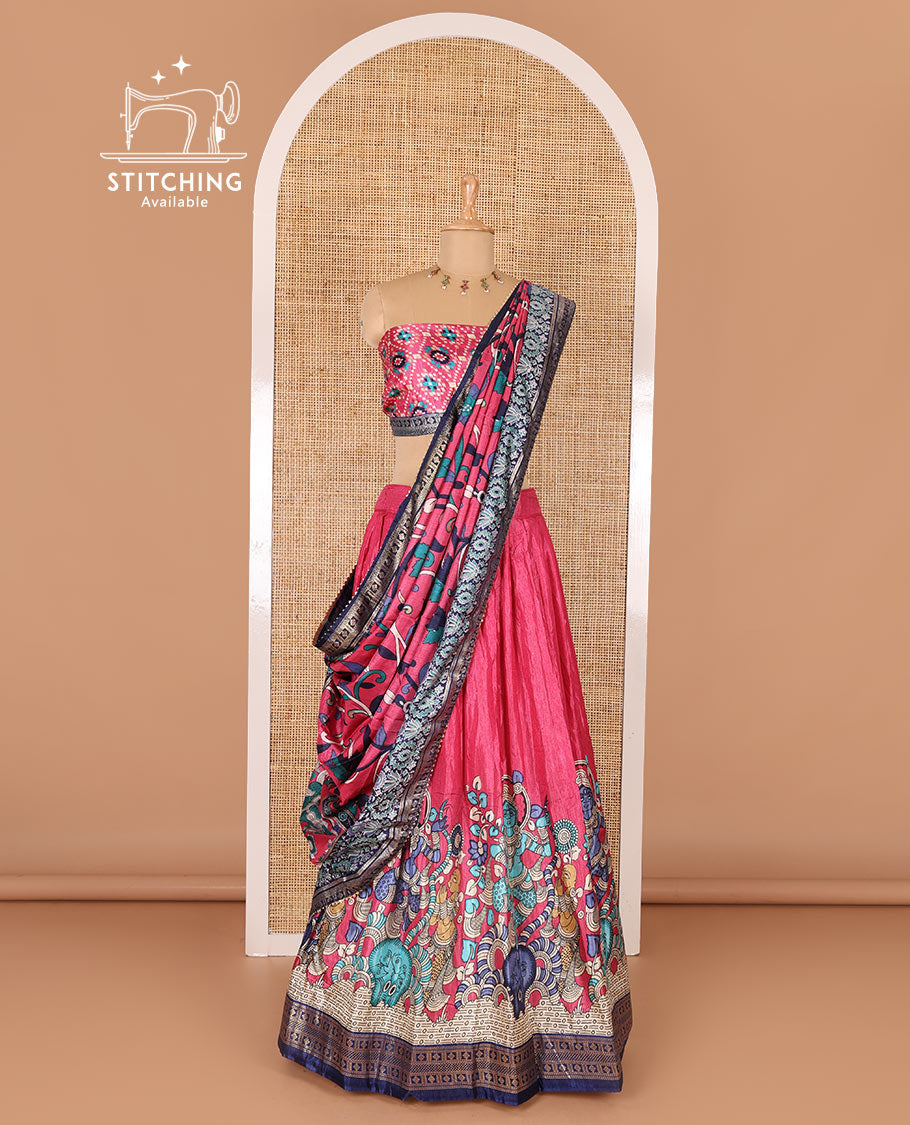 Pink semi-tussar half-saree, kalamkari human figurines printed with a contrast geometric bordered skirt, patola printed blouse, and kalamkari floral vine printed dhavani