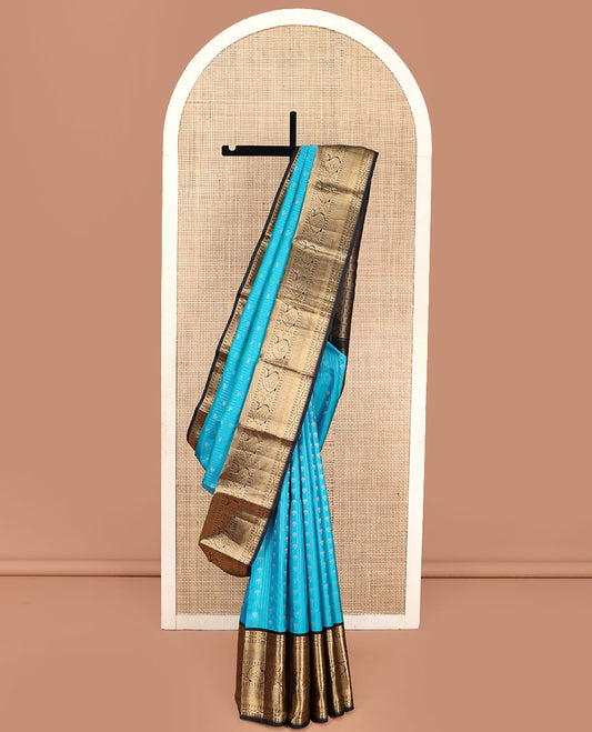 Blue Vasundhara Silk Saree, Adorned with Zari Buttas All Over Its Body, Complemented by Contrast Border of Rekku, Lavangam, Diamond, Mayil Kann, and Arumbu Manga Designs, Pallu of Mughal-Style Jaal Designs, and Paired with a Contrast Blouse