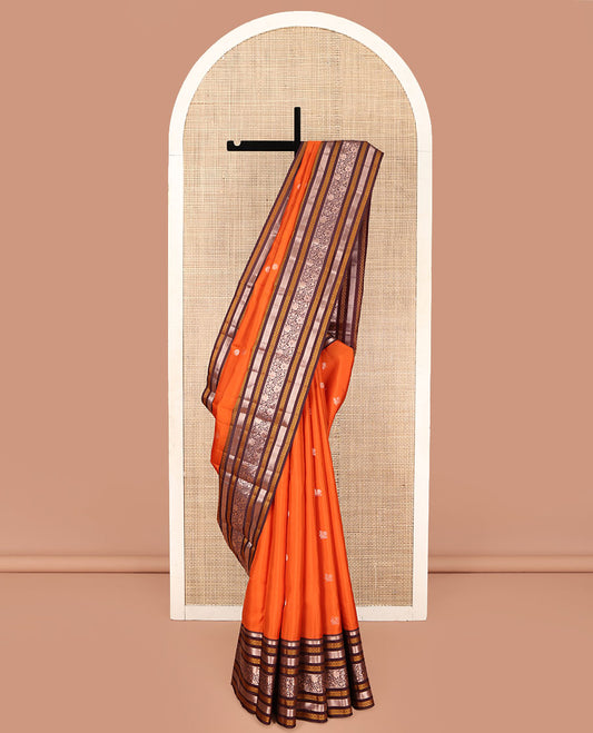 Orange Vasundhara Silk Saree, Adorned with Annam Chakram Buttas All Over Its Body, Complemented by Contrast Border of Thilakam, Neli, Laddu Kamalam, Mayil Kann, and Kodi Visiry Designs, Pallu of Butta Enclosed Checks, and Paired with a Contrast Blouse