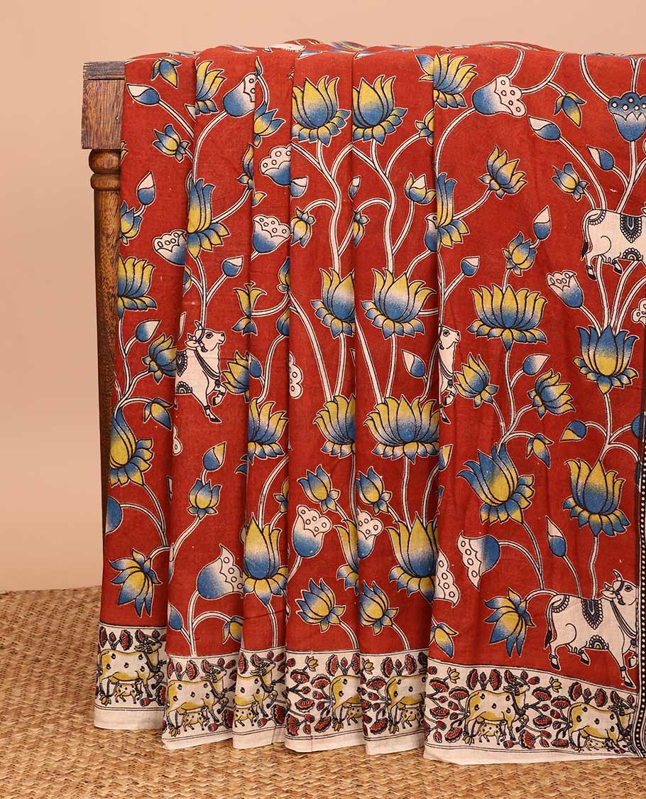 Terracotta red Pichwai and lotus designs machine-printed Kalamkari cotton saree, contrast Pichwai cows printed border, and pallu of temple, peacocks, and diamond designs
