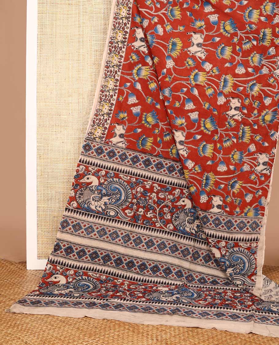 Terracotta red Pichwai and lotus designs machine-printed Kalamkari cotton saree, contrast Pichwai cows printed border, and pallu of temple, peacocks, and diamond designs
