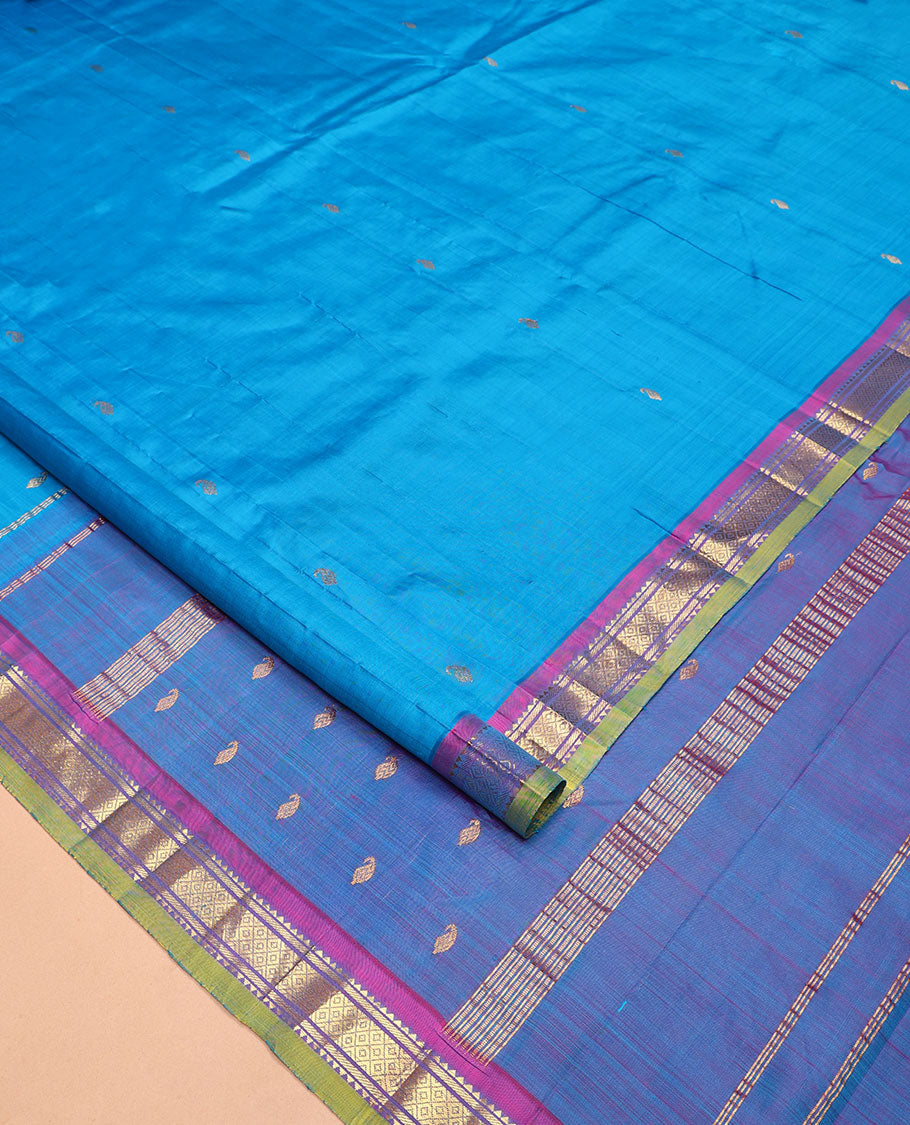 Blue Kanchipuram Silk Saree, Adorned with Zari Buttas All Over Its Body, Complemented by a Contrast One-Sided Border of Rekku, Banaras, and Mayil Kann Designs, Pallu of Zari Designs, and Comes Without a Blouse