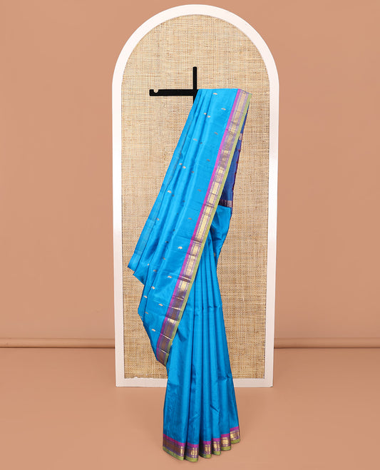 Blue Kanchipuram Silk Saree, Adorned with Zari Buttas All Over Its Body, Complemented by a Contrast One-Sided Border of Rekku, Banaras, and Mayil Kann Designs, Pallu of Zari Designs, and Comes Without a Blouse