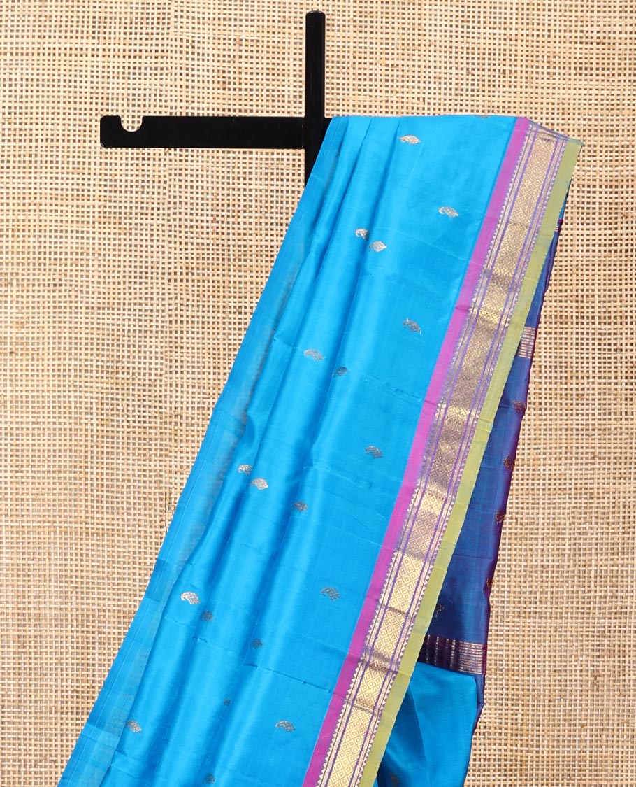 Blue Kanchipuram Silk Saree, Adorned with Zari Buttas All Over Its Body, Complemented by a Contrast One-Sided Border of Rekku, Banaras, and Mayil Kann Designs, Pallu of Zari Designs, and Comes Without a Blouse