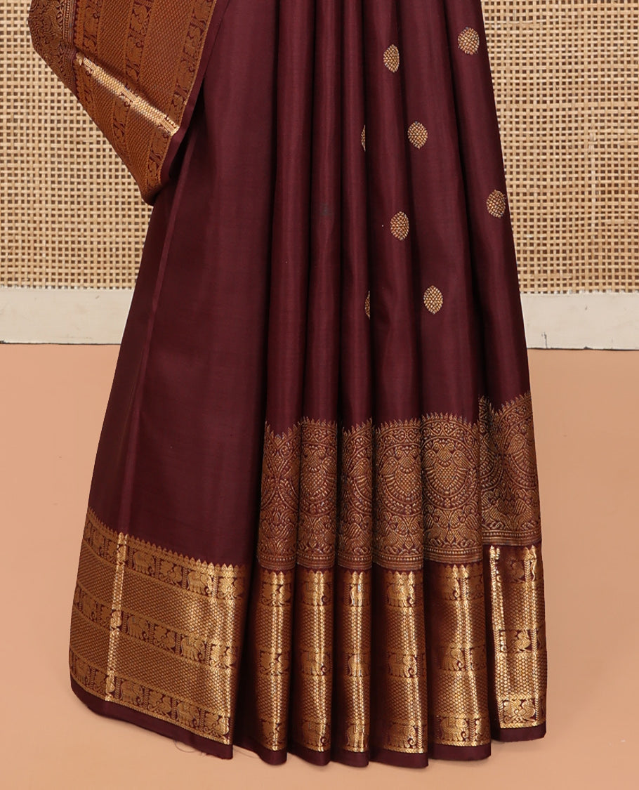 Brown Kanchipuram Silk Saree, Adorned with Zari Buttas, a Zari Border of Iruthalai Pakshi, Thilakam, Kathir, Mayil, Yaanai, and Mayil Kann Designs, Jaal Pallu, and a Matching Blouse
