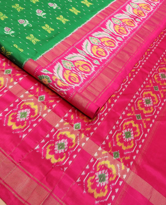 Green Ikkat silk saree features floral Ikkat buttas, highlighted with a contrast Ikkat woven border, a hazily woven Ikkat patterned pallu, and a contrast blouse