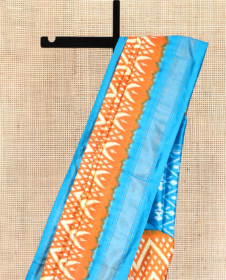 Orange Pochampally Ikat Silk Saree, Ornamented with Buttas and Chevron Design on Its Body, Complemented by a Contrast Border, Pallu of Jaal Designs in Ikkat Weave, and Paired with a Contrast Blouse