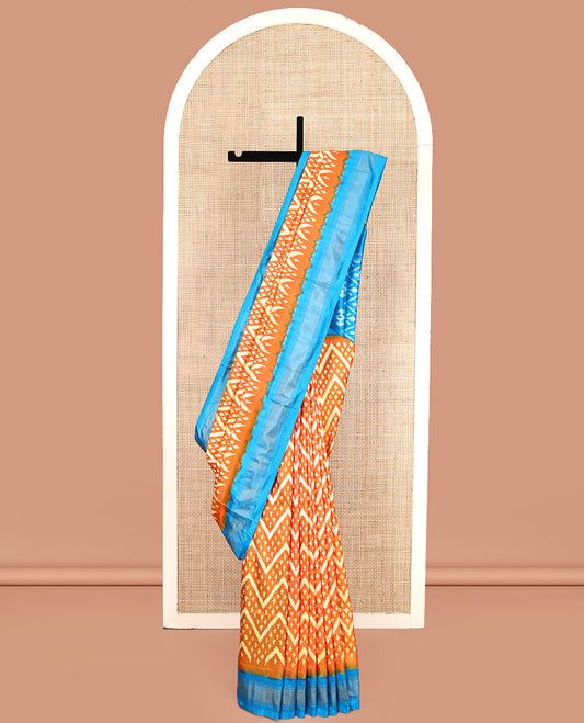 Orange Pochampally Ikat Silk Saree, Ornamented with Buttas and Chevron Design on Its Body, Complemented by a Contrast Border, Pallu of Jaal Designs in Ikkat Weave, and Paired with a Contrast Blouse