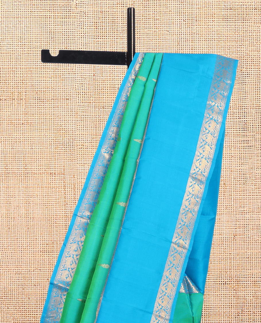 Green Kanchipuram Silk Saree, Ornamented with Zari Buttas, Complemented by Contrast Rettai Pettu Border of Rekku, Muthu, and Mayil Designs, Jaal Pallu, and Contrast Blouse