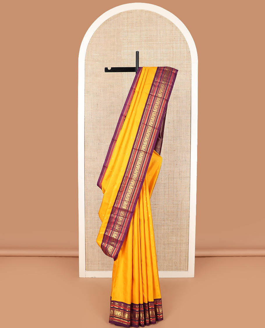 Yellow zari buttas Kanchipuram silk saree, contrast border of thilakam mokku, banaras, kathir, and dhavana manga designs, and mayil kann design pallu