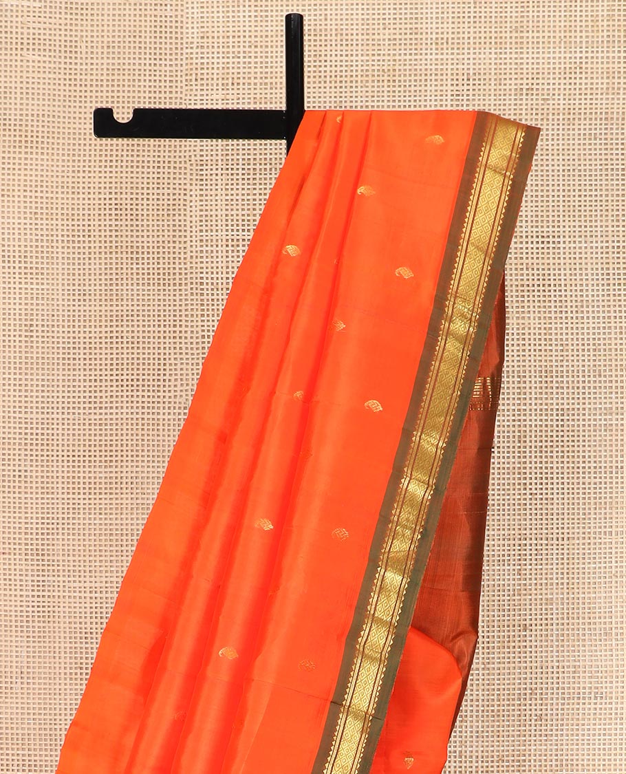 Orange Kanchipuram Silk Saree Mesmerized with Zari Buttas All Over Its Body, Complemented by a Contrast One-Sided Border of Rekku, Banaras, and Mayil Kann Designs, Pallu of Zari Stripes, and Comes Without a Blouse
