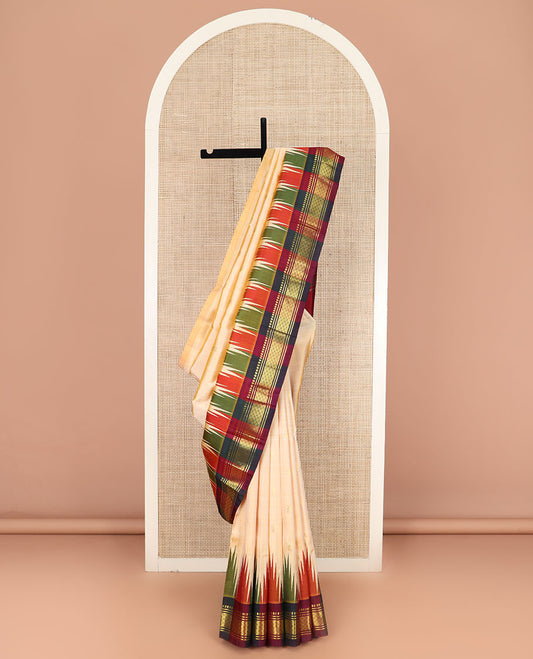 Sandal Kanchipuram Silk Saree Sparsely Sparkled with Zari Buttas, Complemented by Contrast One-Sided Thazampoo Rekku Border of Paneer Sombu, Banaras, and Mayil Kann Designs, Grandly Woven Pallu Steeped with Floral Designs, and Comes Without a Blouse