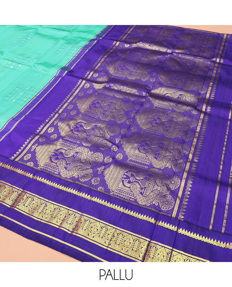 Turquoise Kanchipuram Silk Saree, Subtly Sparkled with Checked Buttas on Its Body, Complemented by a Contrast One-Sided Korvai Border of Thilakam Mokku, and Manga Designs, Pallu of Peacock Chariot Designs, and Comes Without a Blouse