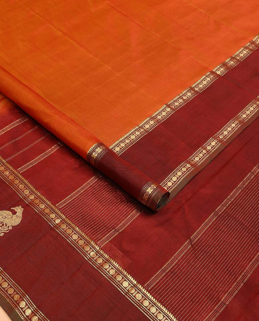 Orange plain Kanchipuram silk saree, contrast border of rekku, muthu, rudraksham and mayil, and zari striped pallu