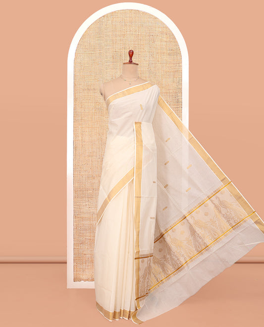 Cream Kerala Cotton Saree, Graced with Zari Buttas All Over Its Body, a Zari Bavanji Border, Pallu Woven with Peacock Designs, and Paired with a Matching Blouse