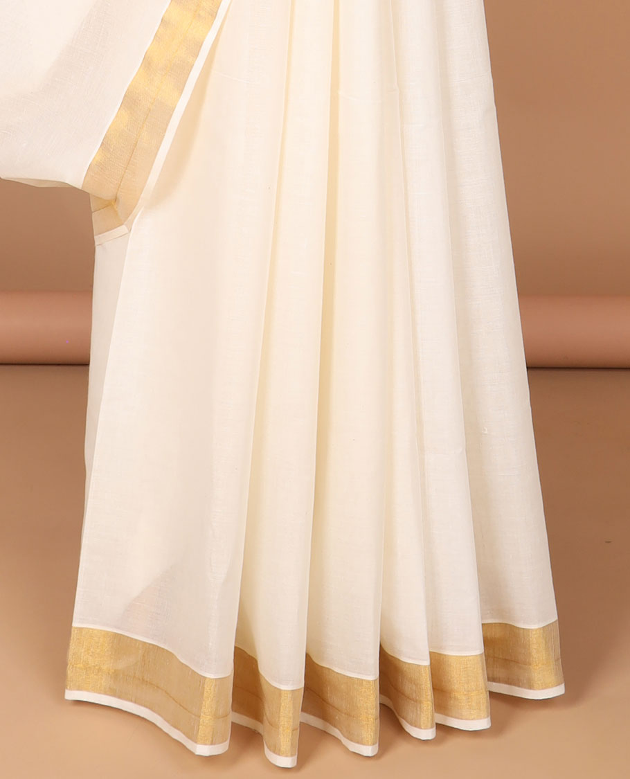 Cream kerala saree adorned with zari designs, zari border & pallu of intricate zari designs