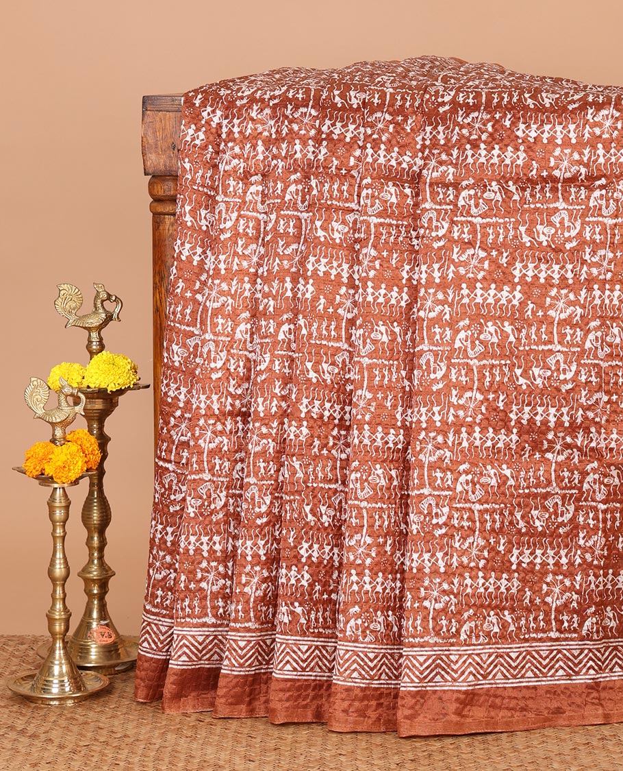 Rust batik-style warli printed Litch crushed saree, batik chevron border, floral-geometric printed pallu & triangle motif blouse