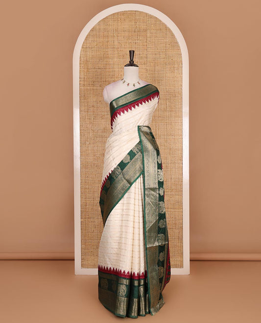 Half-white zari designs dola silk saree, contrast green temple traditional border of peacock and elephant motifs, and temple pallu
