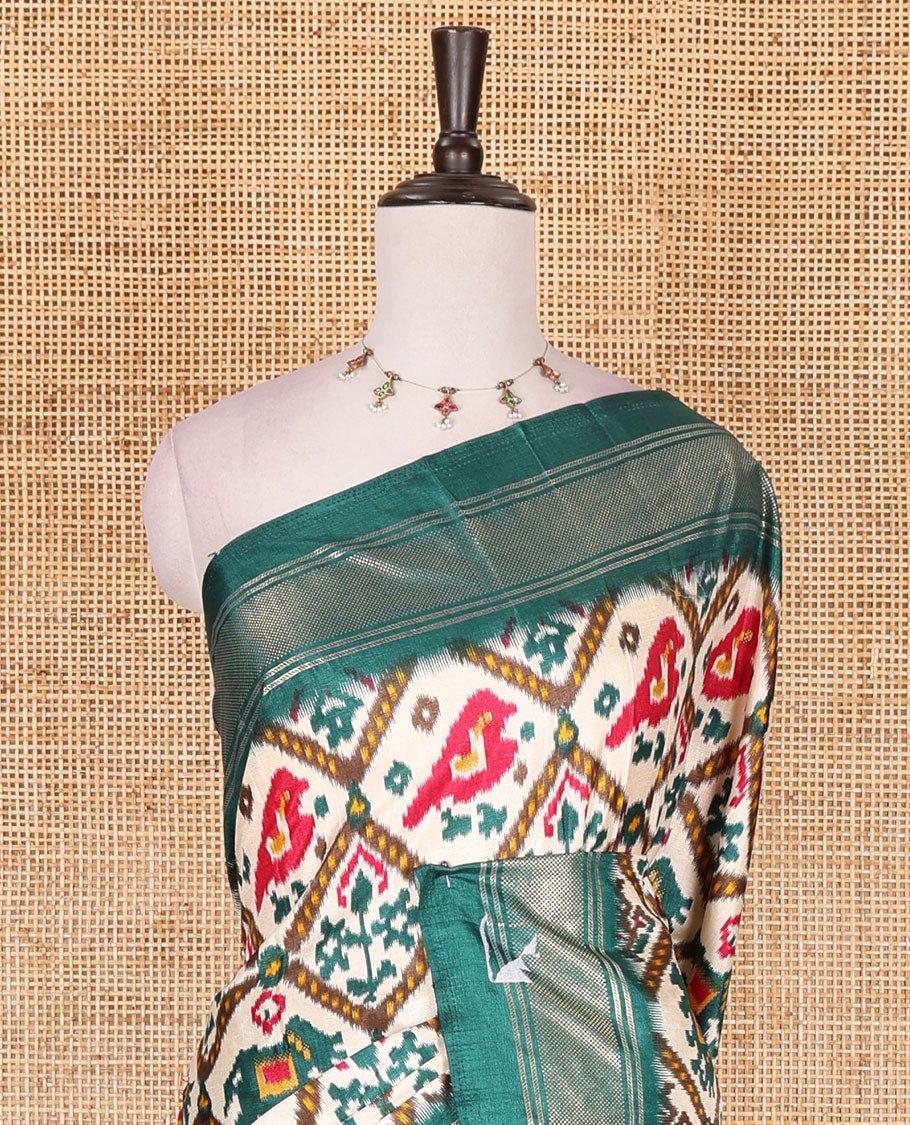 Half-white and green buttas enclosed jaal patterned patola-inspired pochampally dola silk saree, contrast green zari border, patola elephant pallu, and contrast blouse