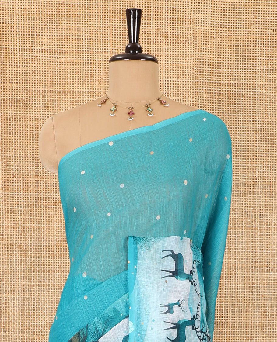 Borderless teal blue Christmas-theme Snow-fall, moon, trees, and deer motifs printed linen cotton saree with a contrast printed blouse