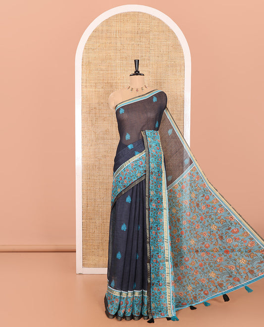 Blue Linen Saree Accentuated with Leaf Motifs All Over Its Body, Complemented by a Contrast Floral Vine Printed Border, Pallu Mirrors the Floral Vine Print, and Paired with a  Contrast Floral Printed Blouse