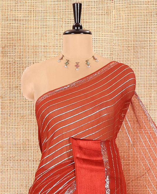 Rust Viscose Georgette Saree Gleamed with Horizontal Golden Zari Stripes All Over Its Body, Accentuated by a Satin Plain Border, a Self Pallu Featuring the Same Horizontal Stripes, and Paired with a Running Blouse