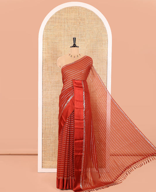 Rust Viscose Georgette Saree Gleamed with Horizontal Golden Zari Stripes All Over Its Body, Accentuated by a Satin Plain Border, a Self Pallu Featuring the Same Horizontal Stripes, and Paired with a Running Blouse