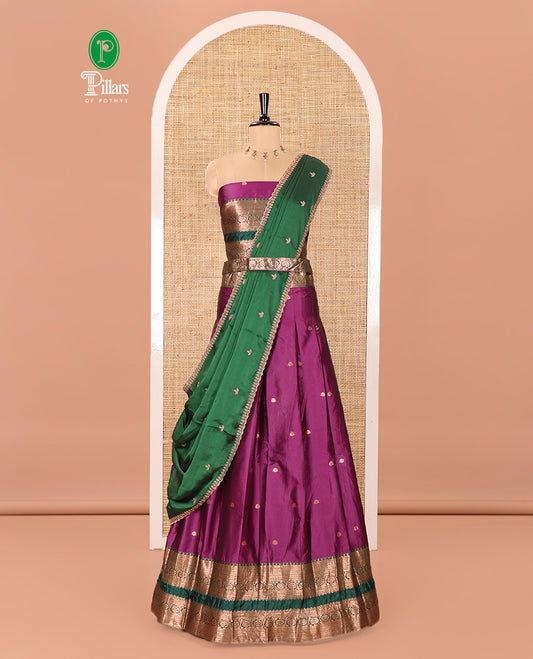 Purple and Green Semi-Banarasi Half-Saree Featuring Zari Buttas Skirt, Complemented by Contrast Rettai Pettu, Traditional Border of Floral Creeper Designs, Paired with a Matching Blouse, and a Satin Georgette Embroidered Scallop Dhavani