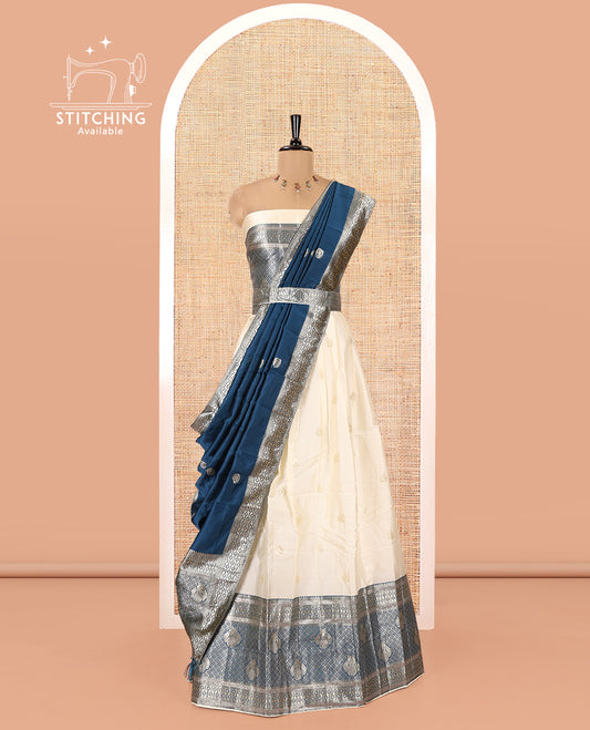 Cream-Peacock Blue Semi-Banarasi Half-Saree Set Featuring Buttas Skirt, Contrast Traditional Border, a Matching Blouse, and a Banaras Dhavani