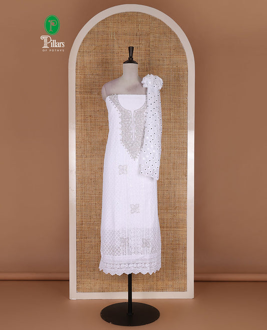 White material churidar set, stone work with Schiffli style embroidered georgette top, American Crape bottom, and polka dotted printed mirror work dupatta