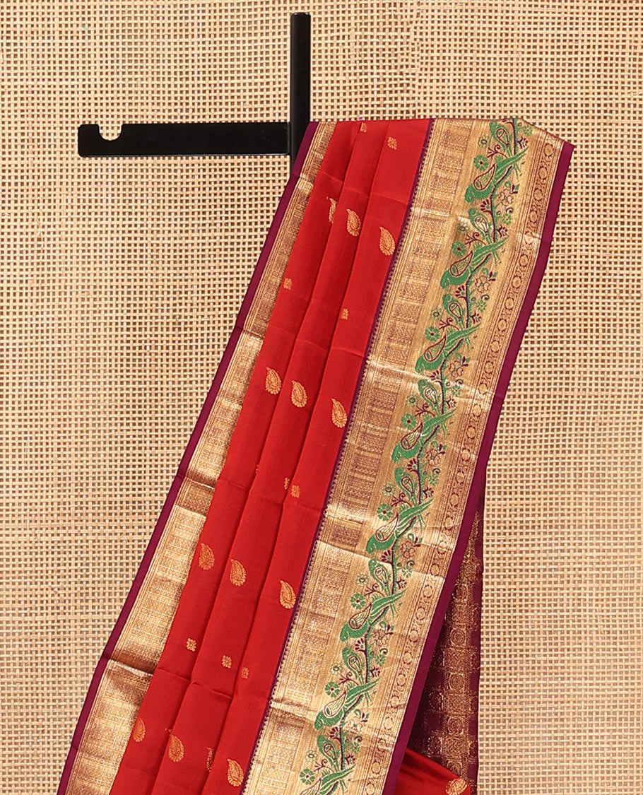 Orange Vasundhara Silk Mix Saree Decorated with Zari Buttas, Features Contrast Border Complemented with Thilakam, Banaras, Kathir, Mayil Kann, and Meenakari Parrot Motifs, a Pallu with Intricate Kanchi Motifs, Paired with a Contrast Blouse