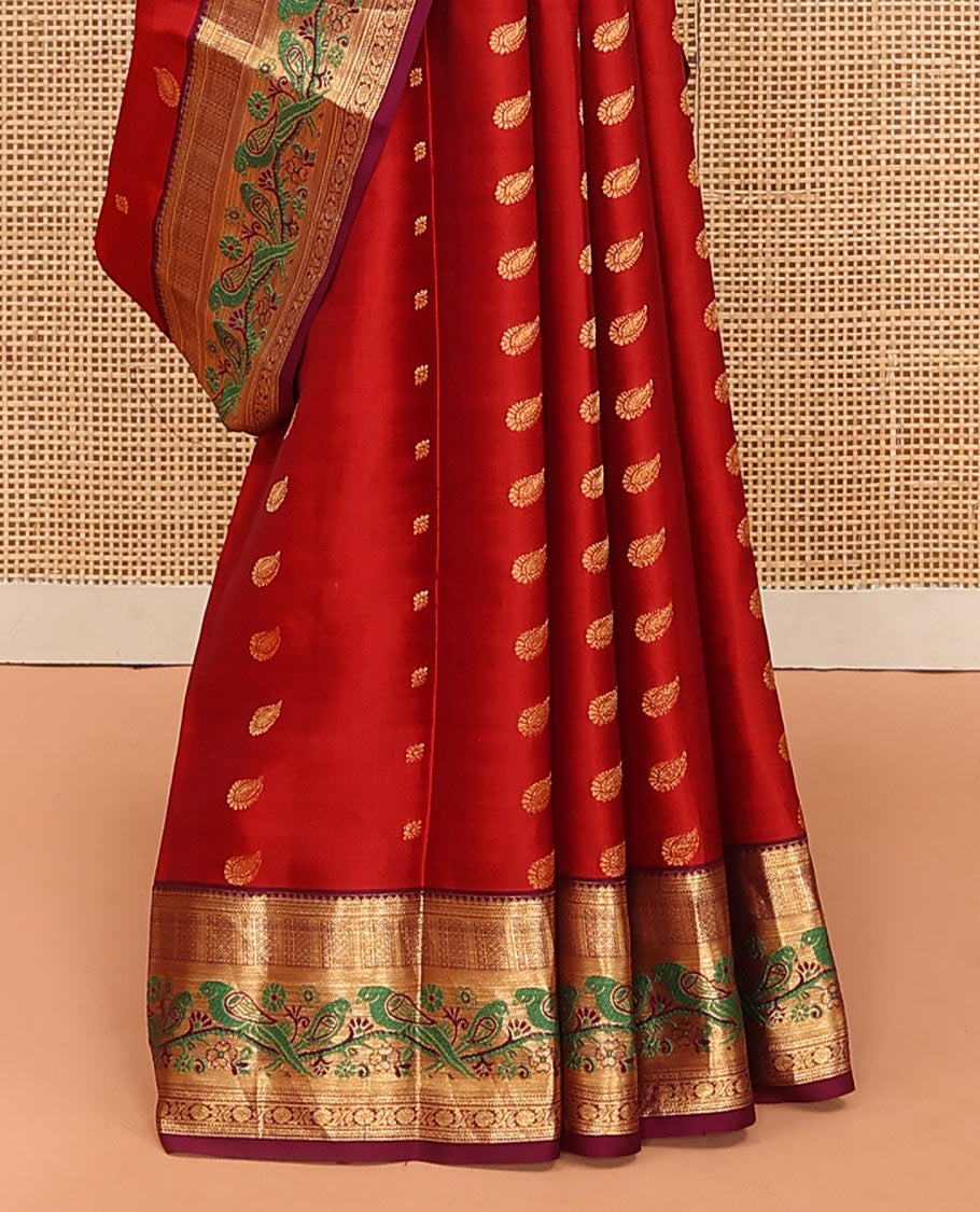 Orange Vasundhara Silk Mix Saree Decorated with Zari Buttas, Features Contrast Border Complemented with Thilakam, Banaras, Kathir, Mayil Kann, and Meenakari Parrot Motifs, a Pallu with Intricate Kanchi Motifs, Paired with a Contrast Blouse