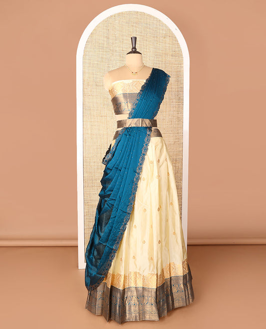 Cream-blue art-silk half-saree, zari buttas with contrast traditional design bordered skirt, a matching blouse, and scallop stone work dhavani