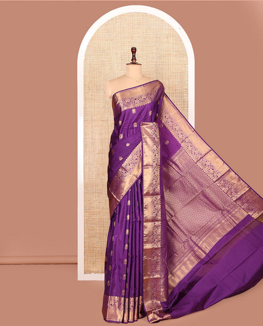 Purple Budget Silk Saree Detailed with Zari Buttas All Over Its Body, Highlighted by a Zari Traditional Border of Floral Creeper Designs, Grand Pallu of Scallop Designs, and Paired with a Matching Blouse