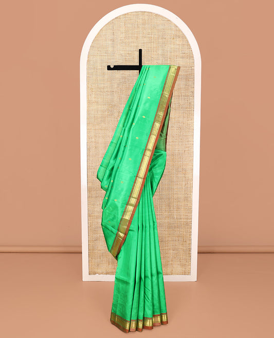 Green Kanchipuram Silk Saree, Embellished with Zari Buttas All Over Its Body, Complemented by a Contrast One-Sided Border of Banaras, and Jaal Designs, Pallu of Zari Designs, and Comes Without a Blouse