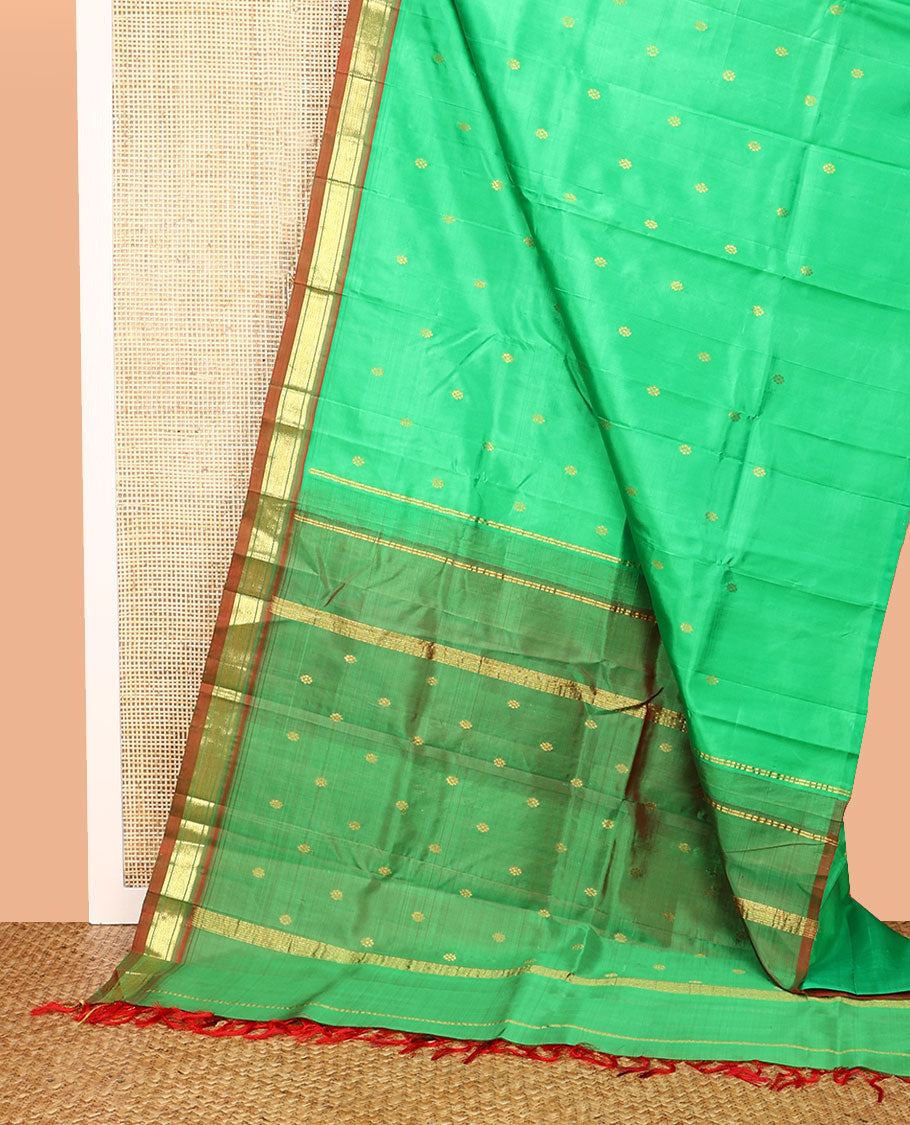 Green Kanchipuram Silk Saree, Embellished with Zari Buttas All Over Its Body, Complemented by a Contrast One-Sided Border of Banaras, and Jaal Designs, Pallu of Zari Designs, and Comes Without a Blouse