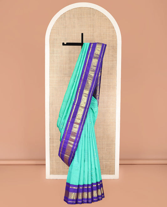 Turquoise Kanchipuram Silk Saree, Subtly Sparkled with Checked Buttas on Its Body, Complemented by a Contrast One-Sided Korvai Border of Thilakam Mokku, and Manga Designs, Pallu of Peacock Chariot Designs, and Comes Without a Blouse