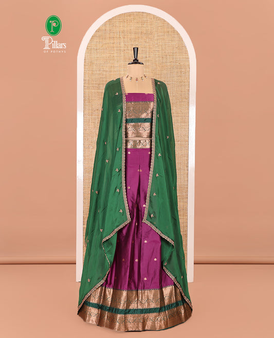 Purple and Green Semi-Banarasi Half-Saree Featuring Zari Buttas Skirt, Complemented by Contrast Rettai Pettu, Traditional Border of Floral Creeper Designs, Paired with a Matching Blouse, and a Satin Georgette Embroidered Scallop Dhavani