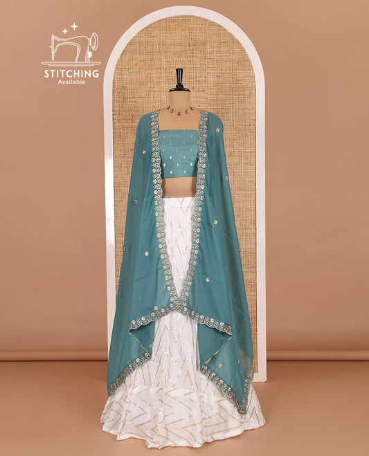Cream-teal blue half-saree, gold chevron striped nylon viscose crepe skirt, contrast diamond buttas blouse, and  a contrast scallop floral-theme embroidered dhavani
