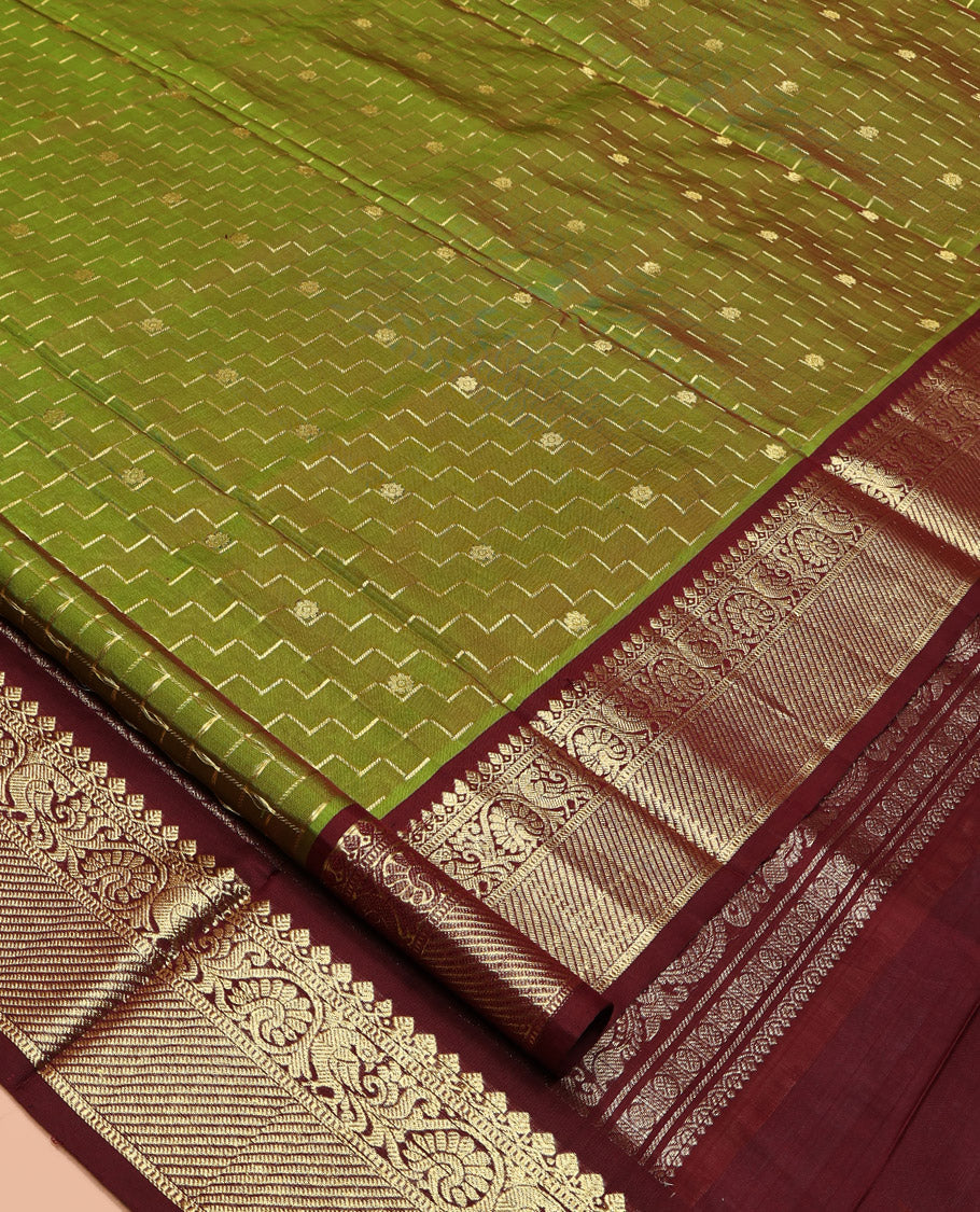 Green Venkatagiri Silk Saree, Delicately Woven with Zari Butta and Chevron Stripes All Over Its Body, Complemented by a Contrast Traditional Zari Border, Pallu of Ogee Designs, and Paired with a Contrast Blouse