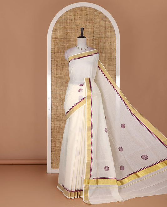 Half-white and maroon chakram motifs printed Kerala cotton saree, temple gold zari border, gold zari pallu, and matching blouse