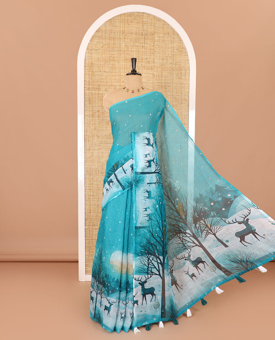 Borderless teal blue Christmas-theme Snow-fall, moon, trees, and deer motifs printed linen cotton saree with a contrast printed blouse