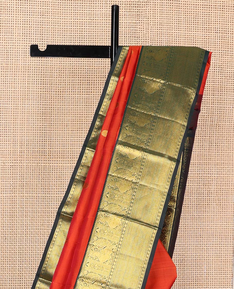 Orange chakram buttas Kanchipuram korvai silk saree, contrast neer korvai border of rekku, muthu, mayil, chakram, poun, and kuyil kann designs, and jaal pallu