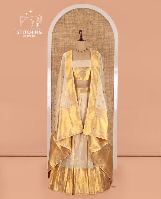 Cream Semi-Banarasi Tissue Half-Saree Features a Plain Skirt, a Traditional Border, Matching Blouse, and Intricate Dhavani