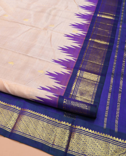 Light Peach Kanchipuram Silk Saree, Subtly Sparkled with Zari Buttas, Complemented by Contrast One-Sided Border of Thilakam Mokku, Banaras, and Godhumai Designs, Pallu of Zari Designs, and Comes Without a Blouse