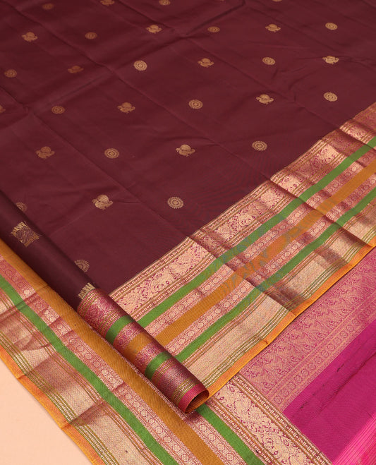 Brown Vasundhara Silk Saree, Delicately Woven with Mayil-Chakram Buttas, a Contrast Border of Kathir, Mayil, Yaanai, Muthu, Neli, and Laddu Kamalam Designs, a Grand Pallu, and a Contrast Blouse